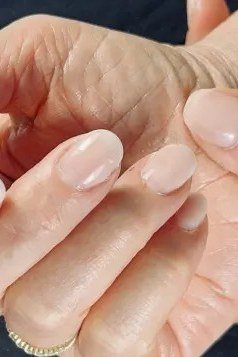 Hand with clear glossy polish for women over 60 - simple clear nail idea 12
