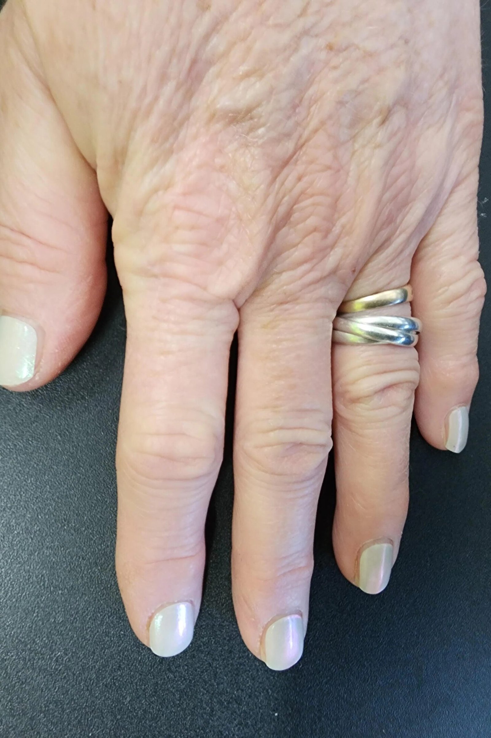 Aged hand with ring, milky white sheer polish for women over 60 - simple clear nail idea 50