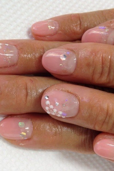 Hands, tiny white daisies on sheer pink for women over 60 - simple clear nail idea 54