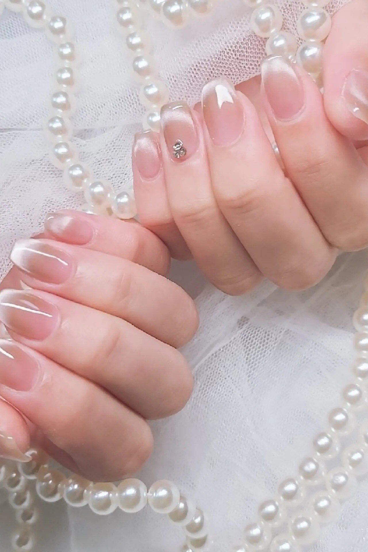 Hands with pearls, sheer pink polish for women over 60 - simple clear nail idea 61