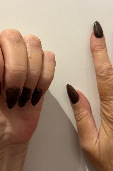 Dark chocolate glossy polish on older hands, short nails