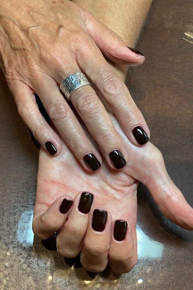 Short dark chocolate nails on older hands