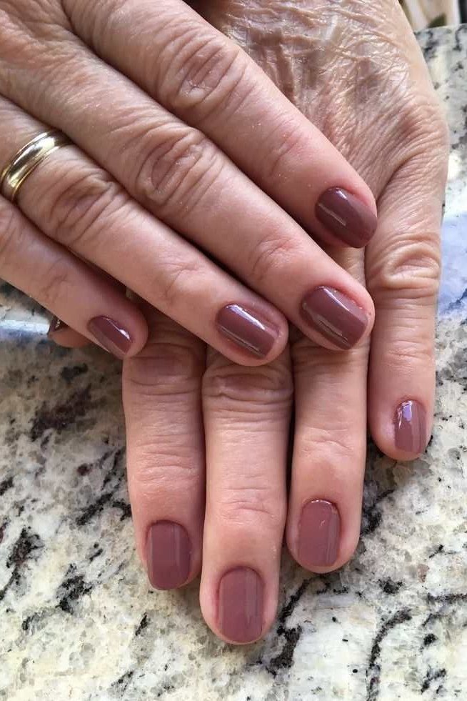 Soft taupe cream polish on older hands