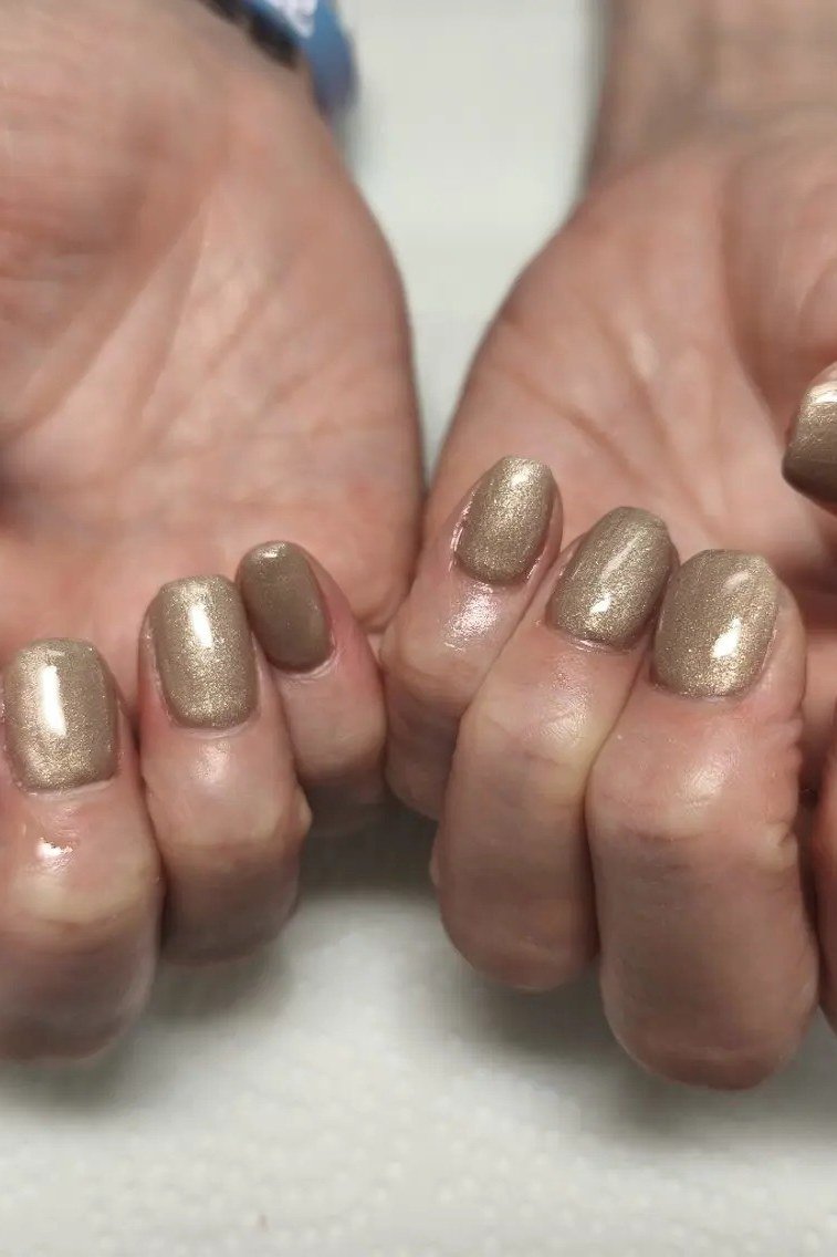 Gold shimmer polish on mature hands