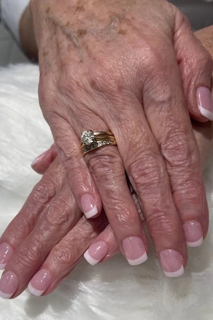 Pink French manicure with soft pink tips on aged hands
