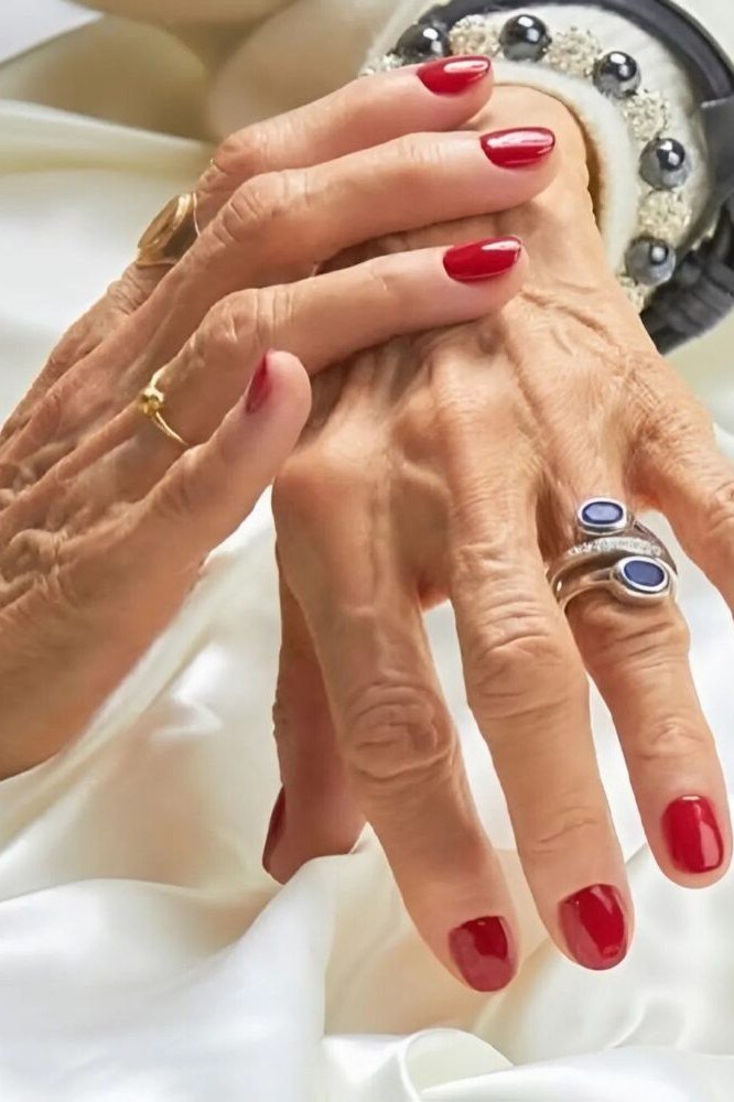 Classic red polish on aged hands
