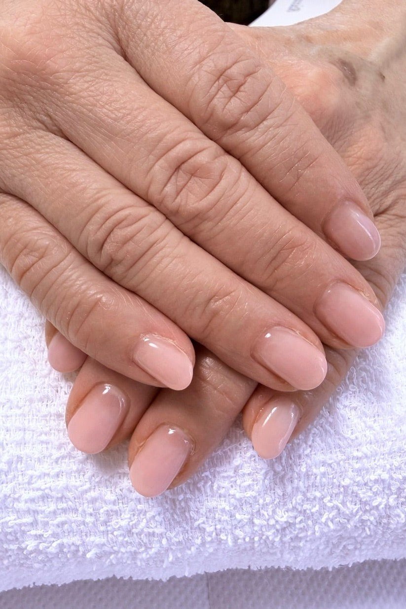 Pale nude polish on aged hands