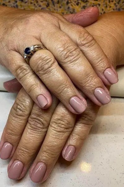 Mauve nude cream nails on aged hands