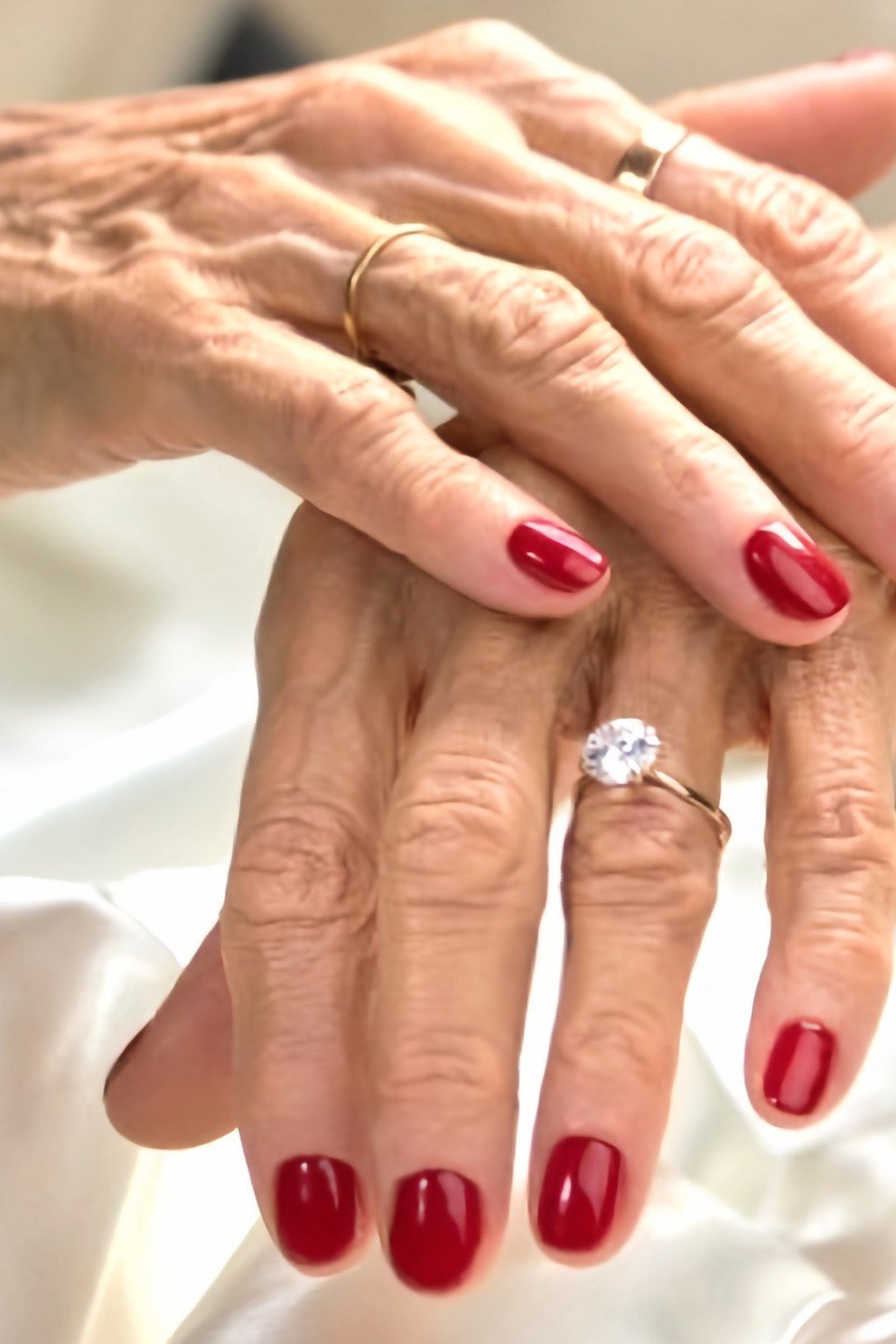 Classic red manicure with diamond ring for women over 60