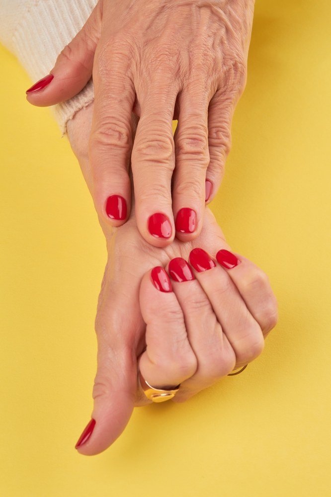 Bright red oval nails on yellow background for women over 60