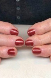 Copper red metallic polish close-up on thumbs for women over 60