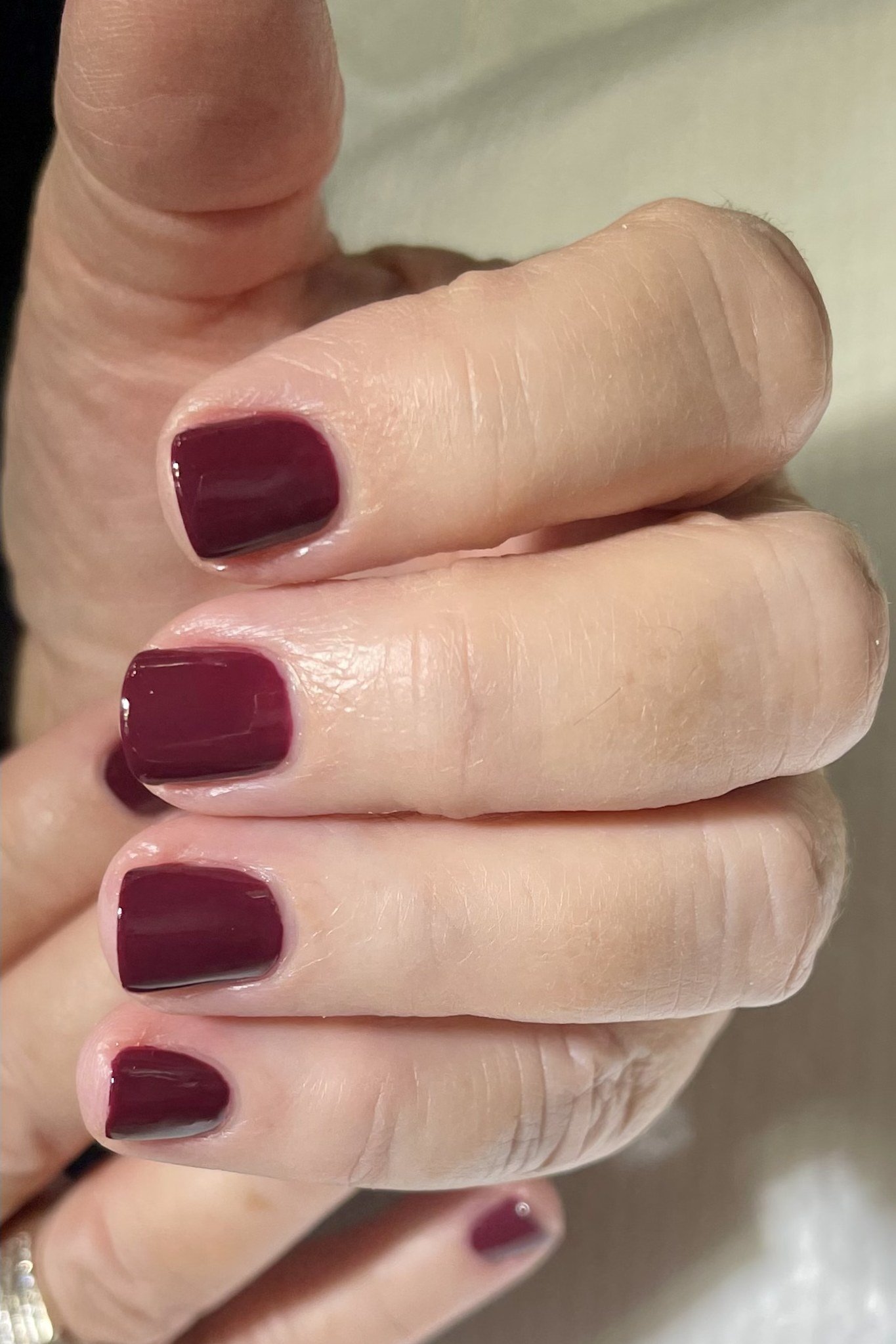 Deep plum red glossy nails wet-look shine for women over 60
