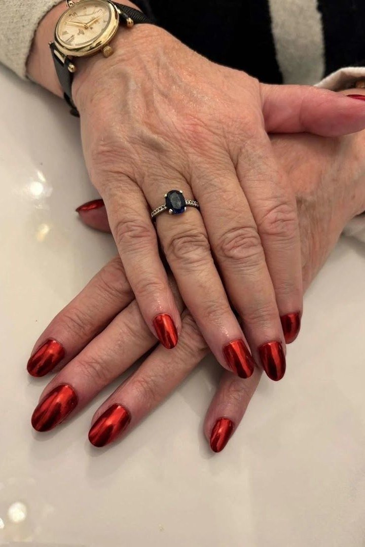 Metallic copper red manicure with classic watch for women over 60