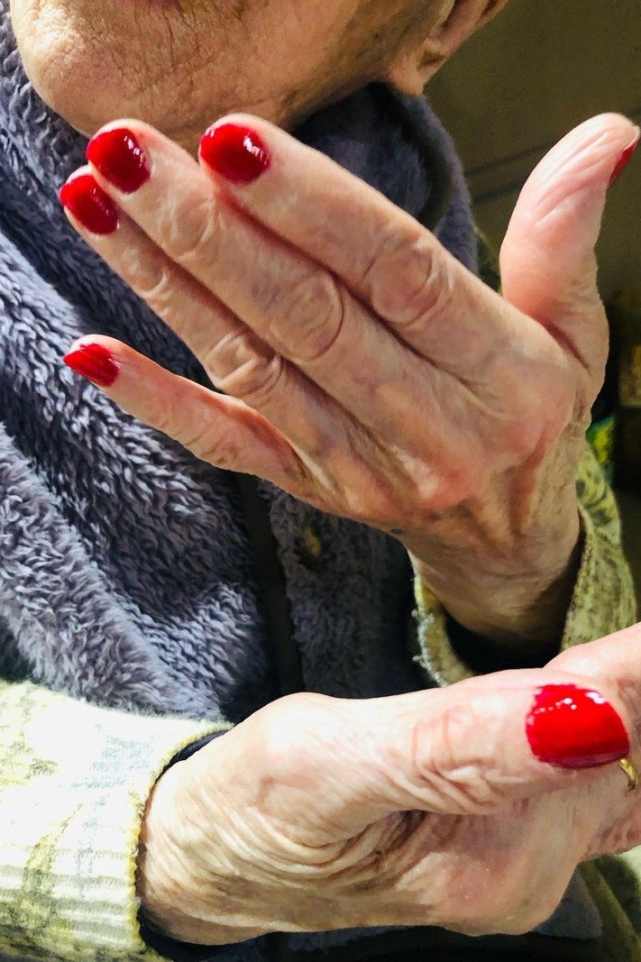 Bright red nails with chunky knit sweater for women over 60