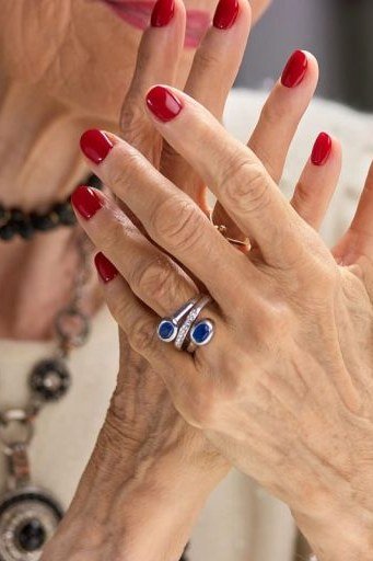 Vivid red nails with deep blue stone ring for women over 60