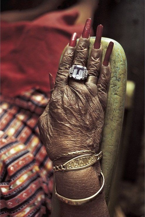 Classic red nails with silver rings and dark scarf for women over 60