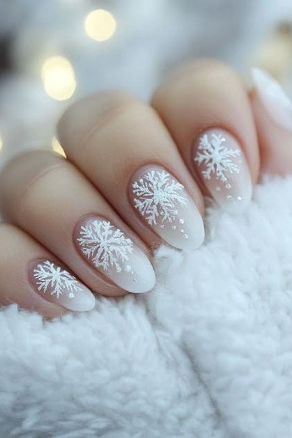 Nude nails with white snowflake french tips, subtle winter design