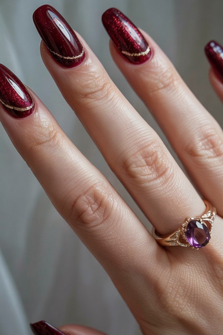 Burgundy almond nails with gold rings, elegant winter nail color over 60