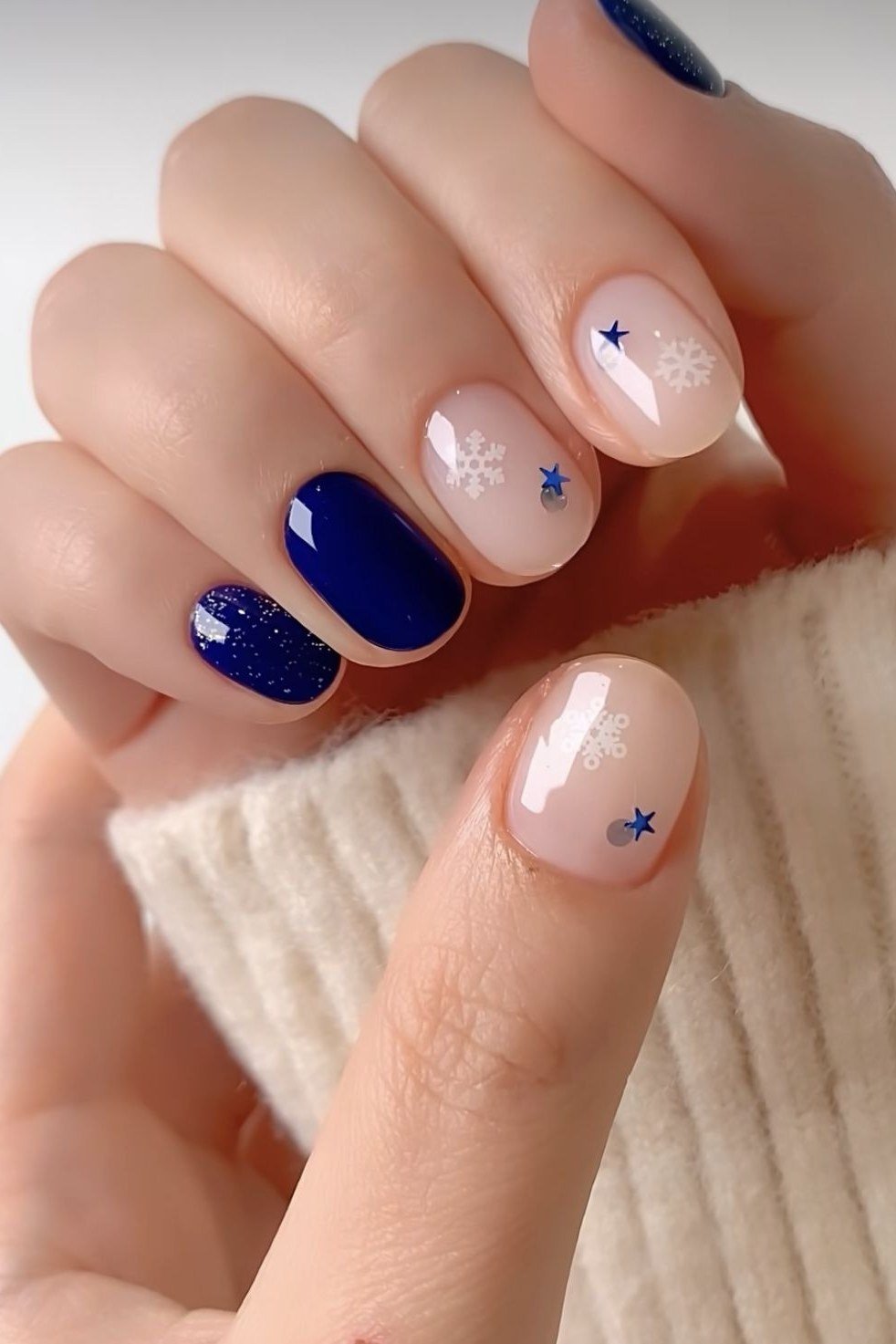 Navy nails with white star and snowflake art, winter night sky nails