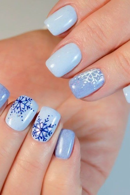 Powder blue nails with white and blue snowflake accents