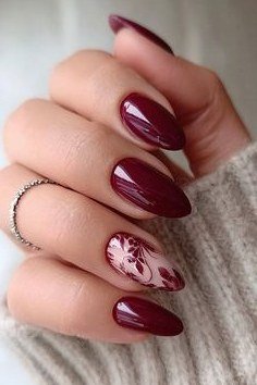 Burgundy nails with white snowflake accents, cozy winter design