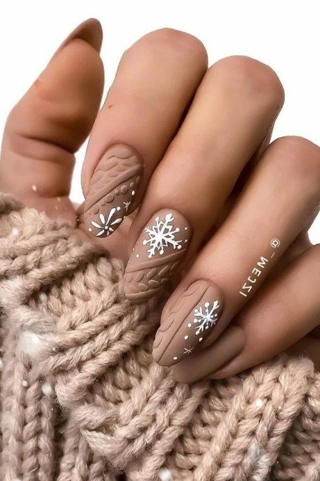 Taupe nails with sweater texture and white snowflake art