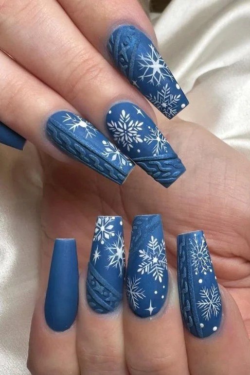 Cobalt blue nails with white snowflakes and sweater texture