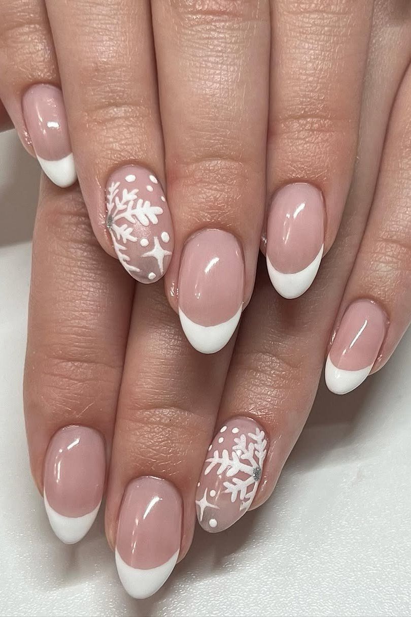 White french tip nails with snowflake art on soft pink base