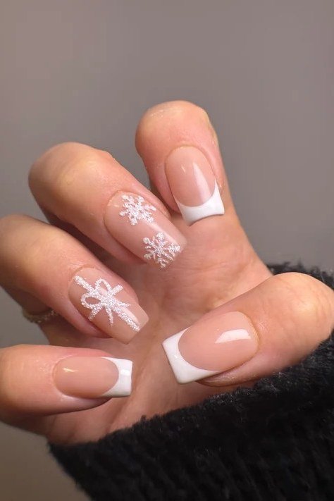 Classic nude french tip nails with white snowflake accents