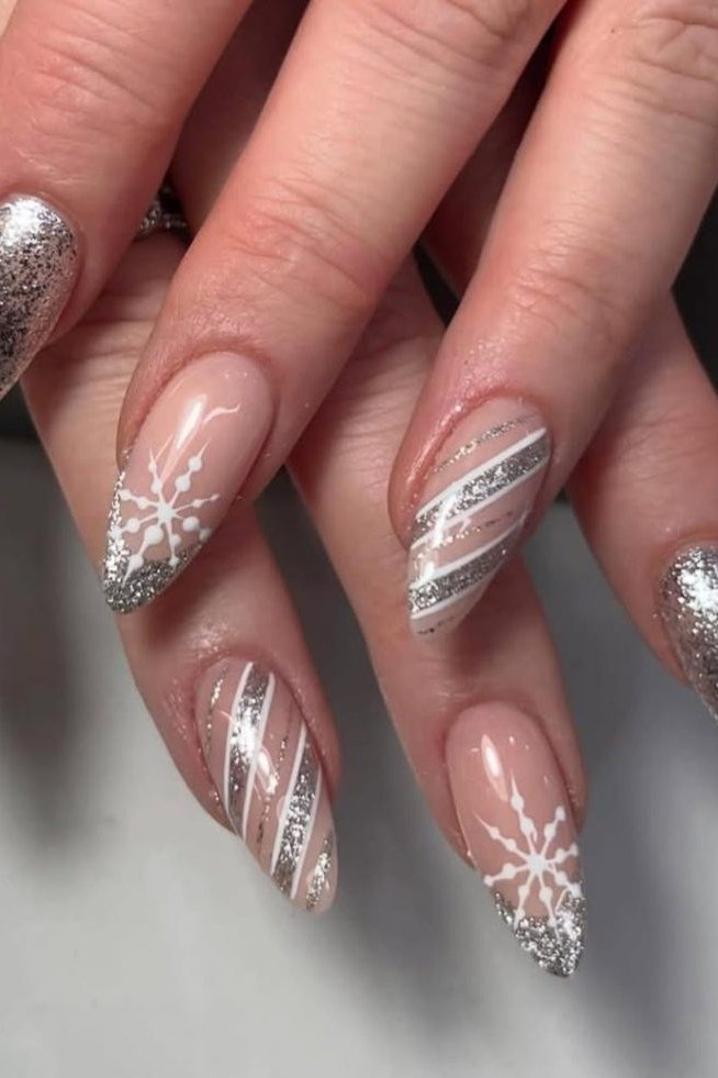 Silver glitter nails with white snowflake accents, frosty holiday nails