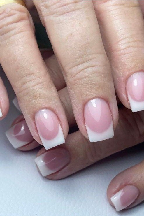 Elegant pink French tips with gold jewelry, glamorous for women over 40