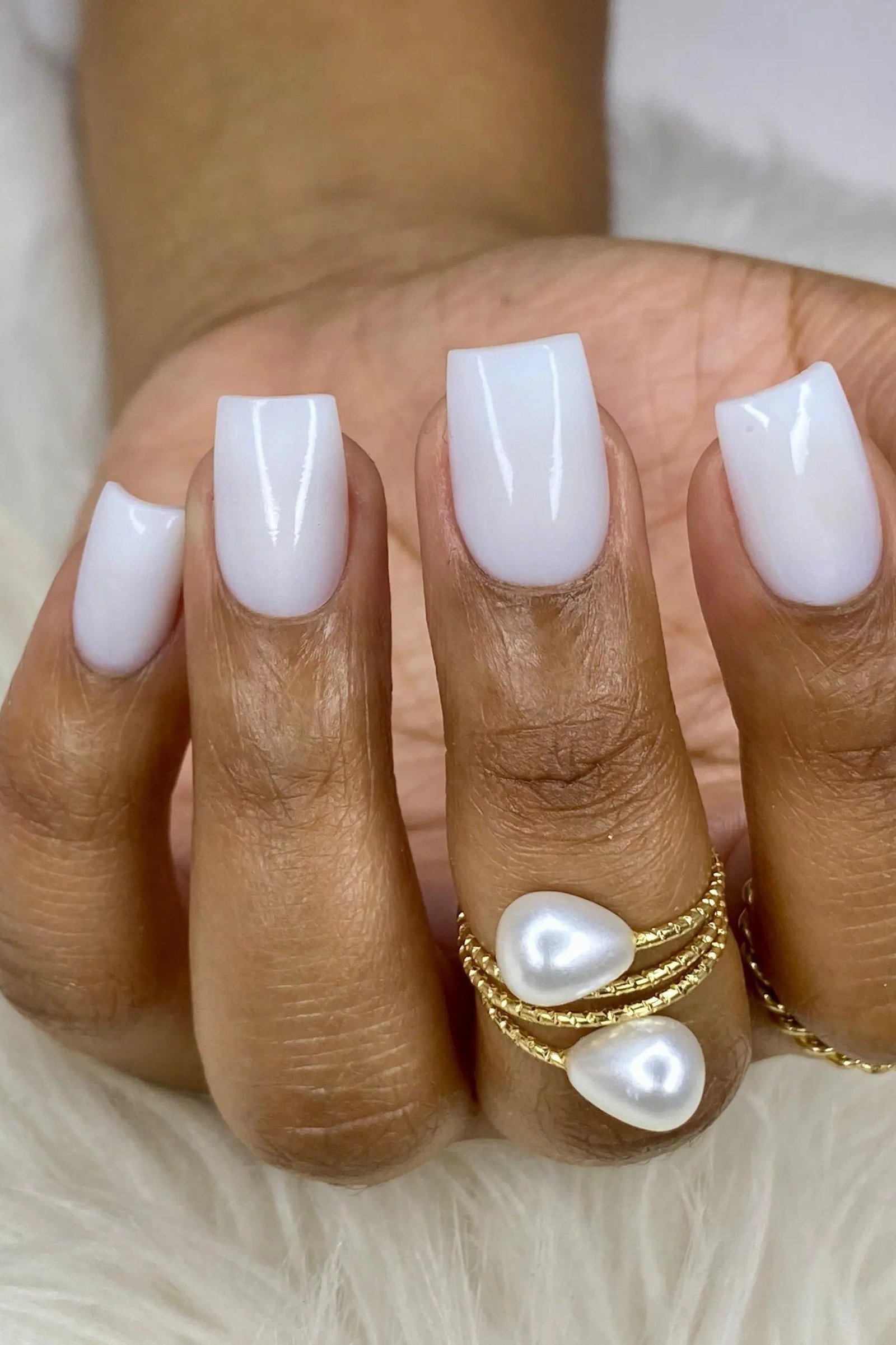 Elegant solid milky white almond nails with a pearl ring for women over 40