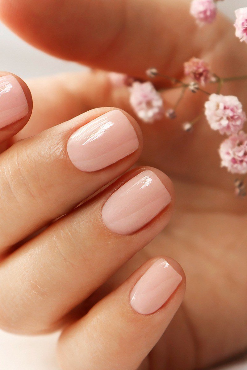 Elegant soft pink nails holding baby's breath flowers for women over 40
