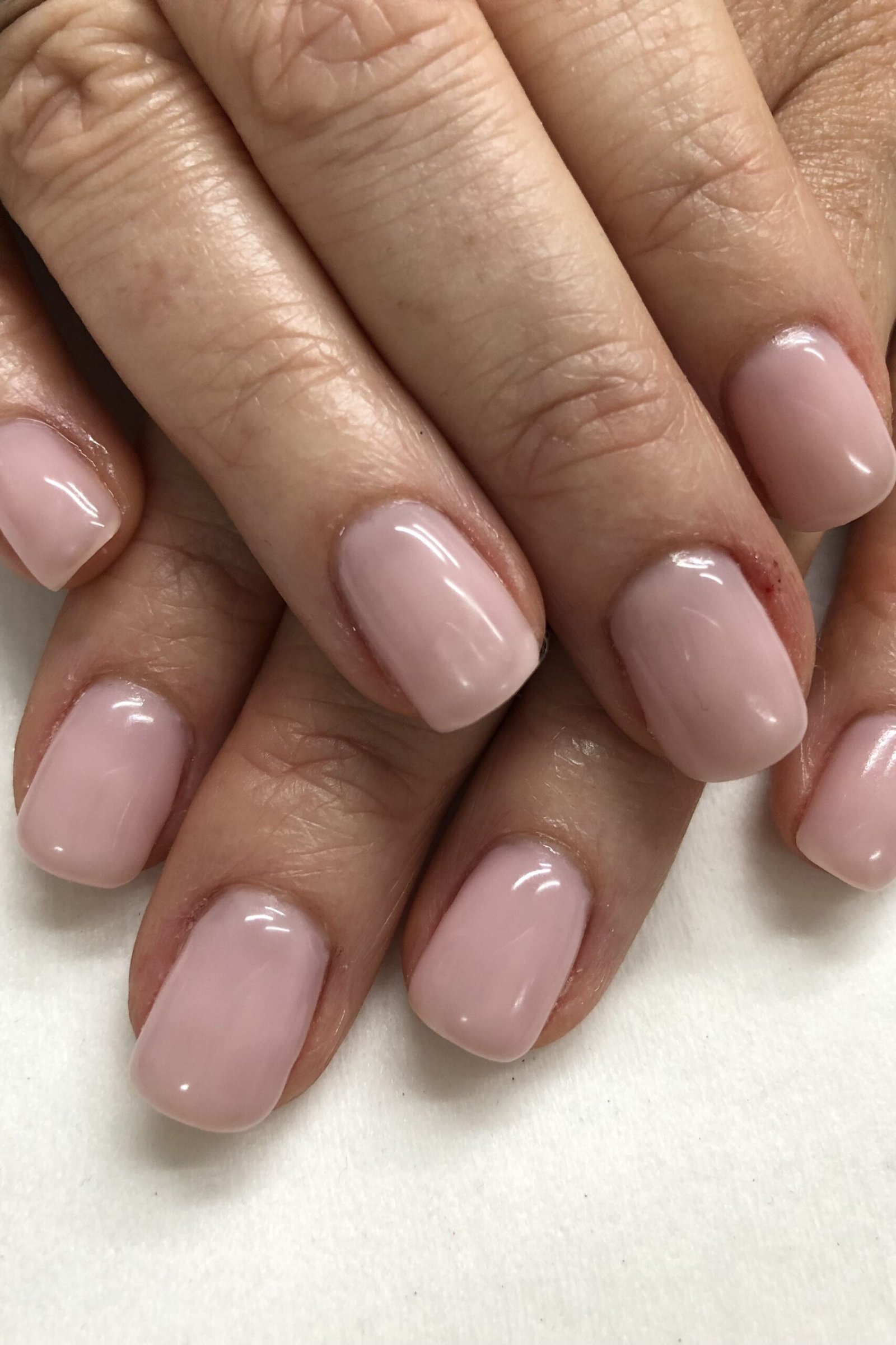 Elegant mauve glossy nails on mature hands for women over 40