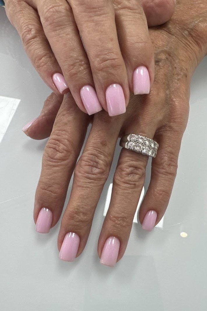 Elegant pink ombre nails on aged hands with diamond ring for women over 40