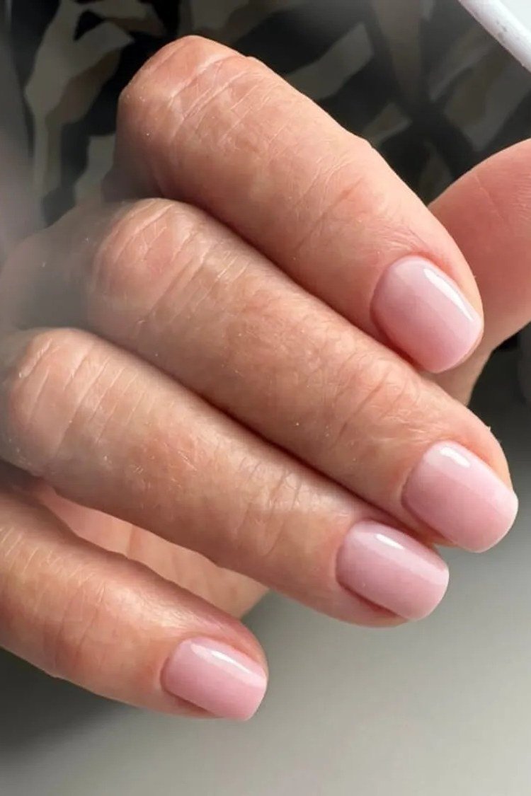 Elegant sheer pale pink nails on a relaxed fist for women over 40