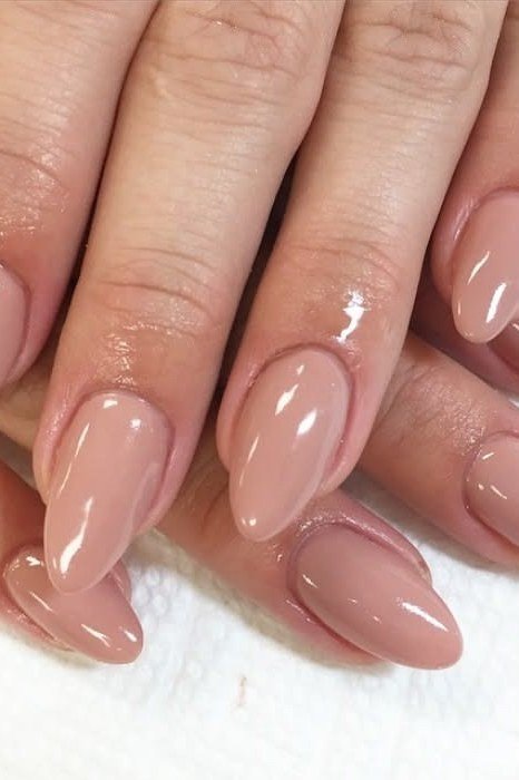 Glossy nude almond nails on hands