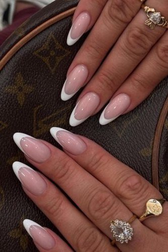 Almond french tip nails with white tips, designer bag and rings