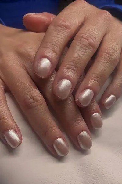 Pearl-white nails, mature hands with darker skin tone