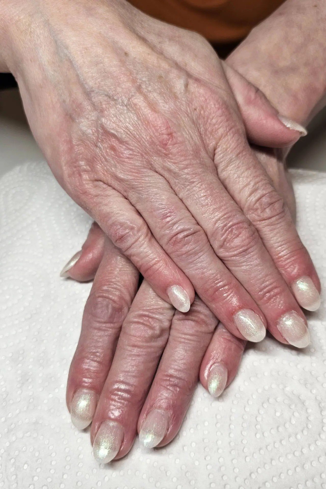 Pearl sheen nails, very wrinkled mature hands