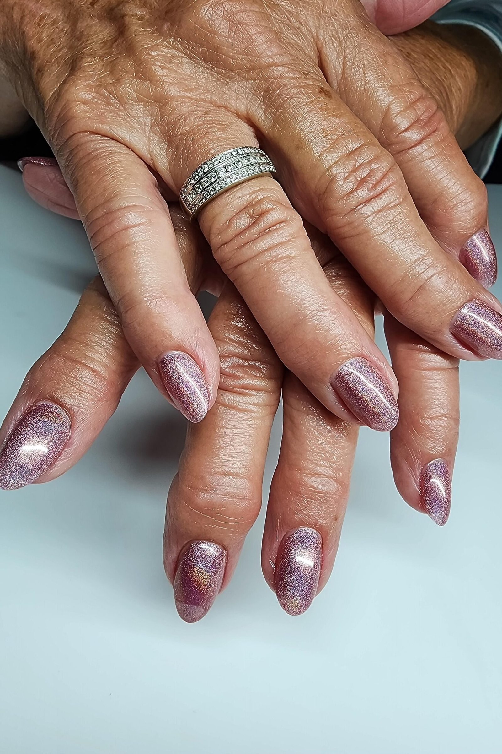 Mauve chrome nails, mature hands with diamond ring
