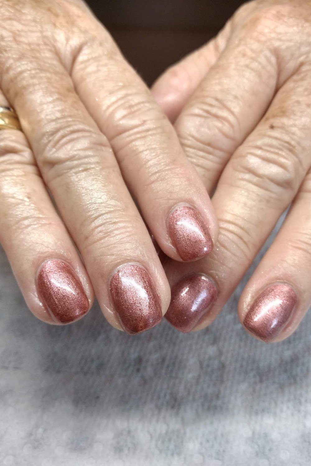Rose gold chrome nails, older hands with rings