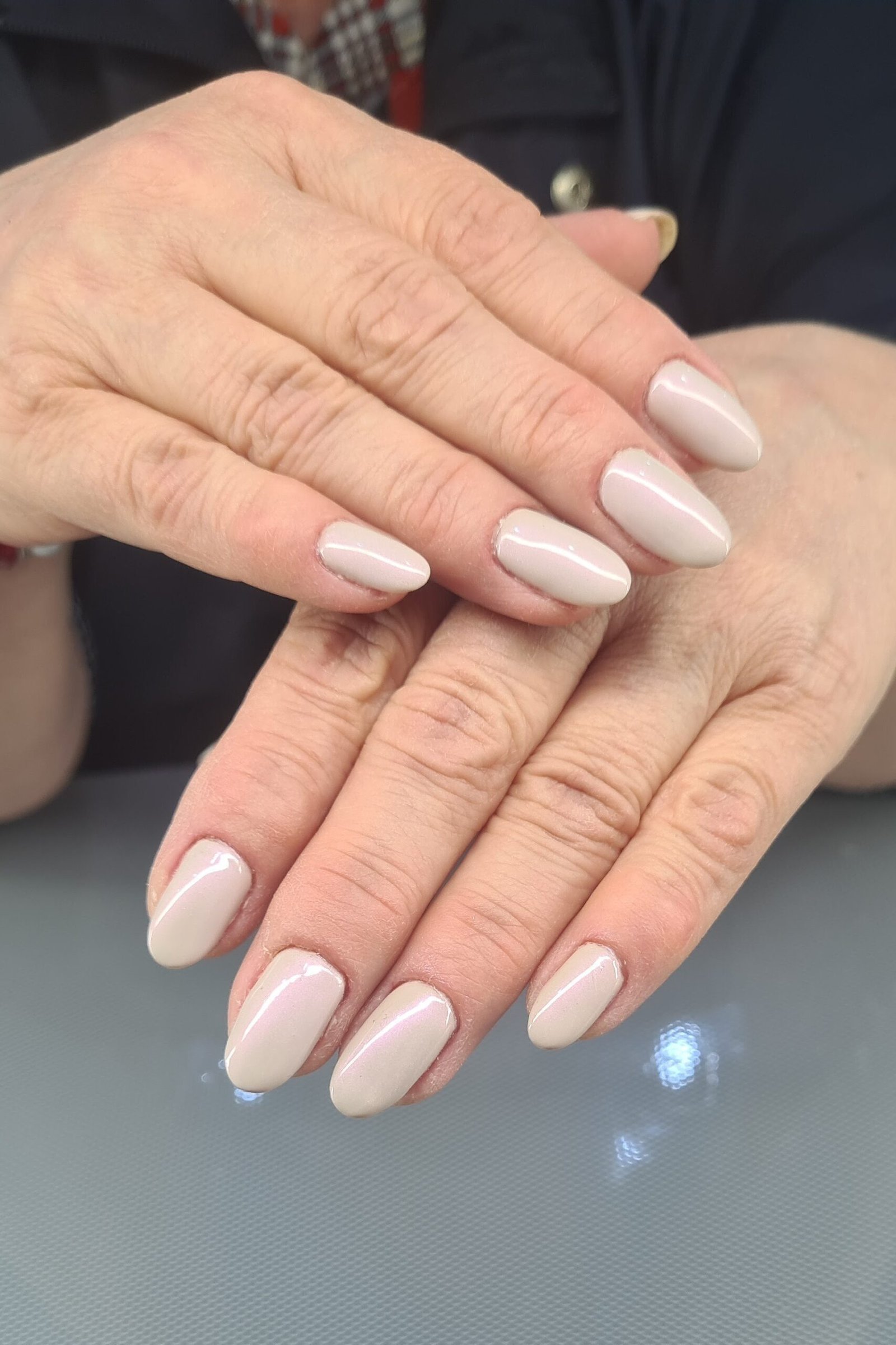 Pearl-white shimmer nails, mature hands