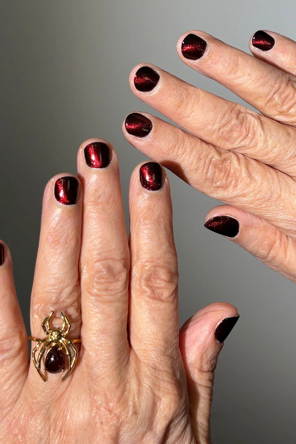 Near-black wine nails, mature hands