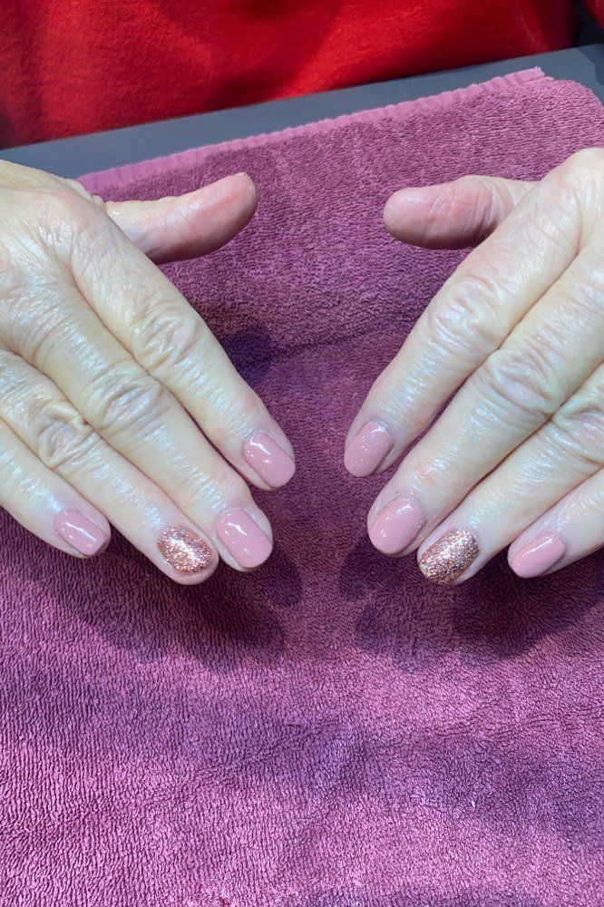 Sheer Pink With Glitter on a Purple Towel - nail color idea for women over 60
