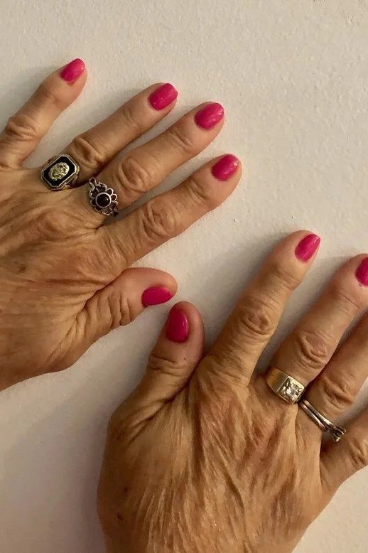 Bright fuchsia-pink nails, older hands