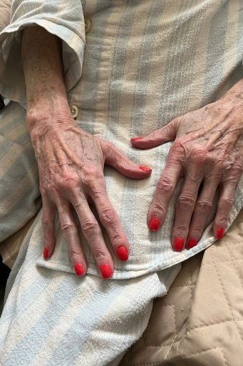 Coral-red nails, older hands