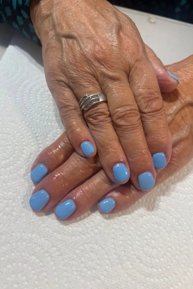 Sky blue nails, mature hands with silver ring