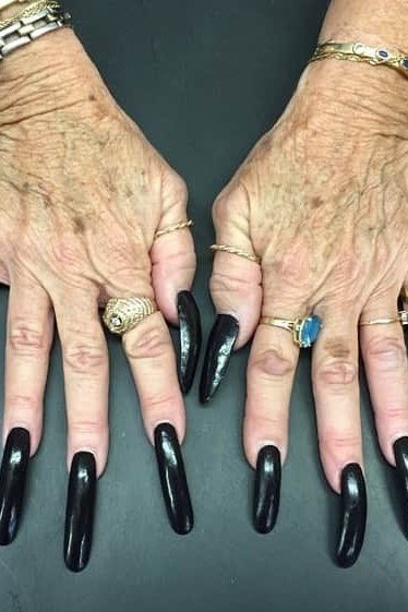 Glossy black almond nails, elderly hands with rings