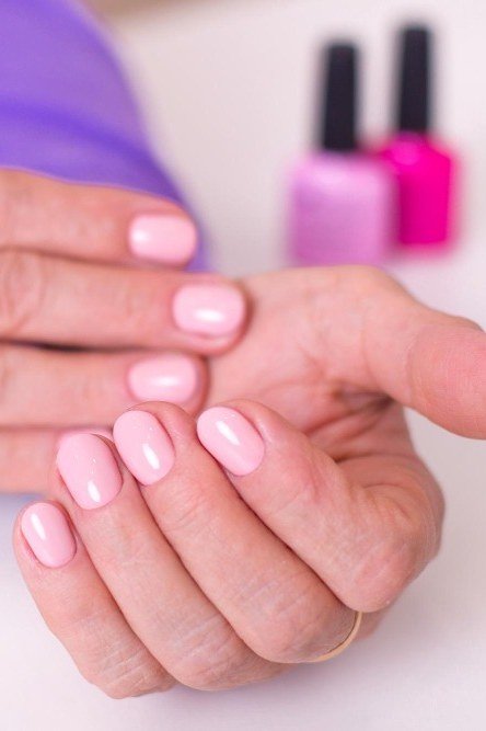 Short pink round nails, older woman hands